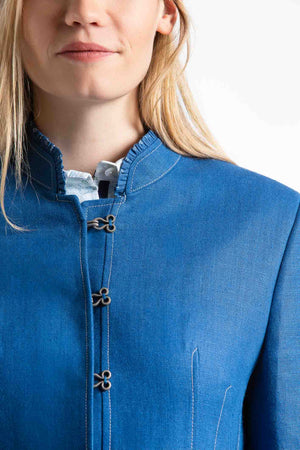 portrait of a young blonde women wearing a blue Austrian linen riding jacket