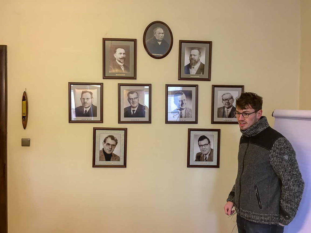 Maximilian Mehler standing in front of pictures of his ancestors who ran the family owned and operated mill before him in Bavaria, Germany