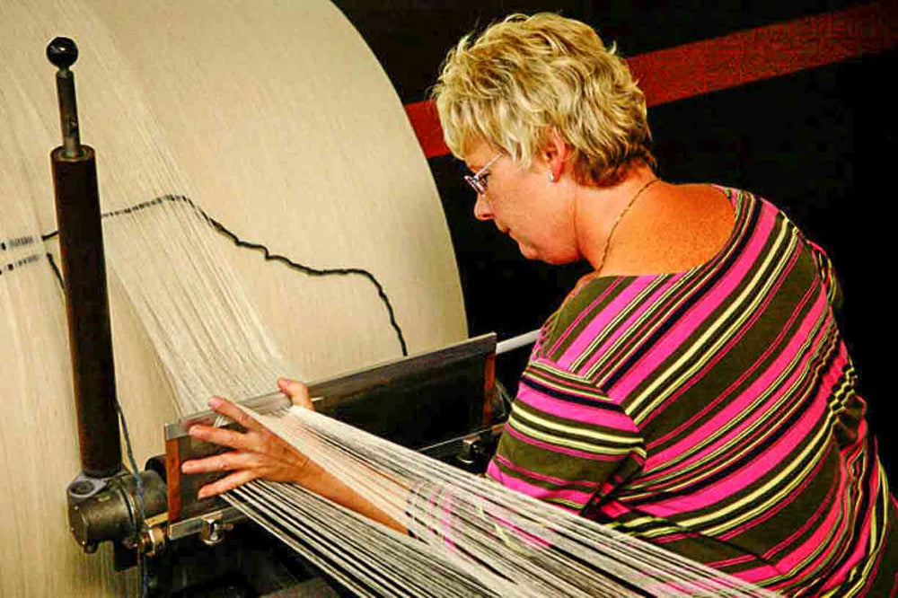 german woman preparing the warp for a loden fabric at the German tradtional Mehler mill