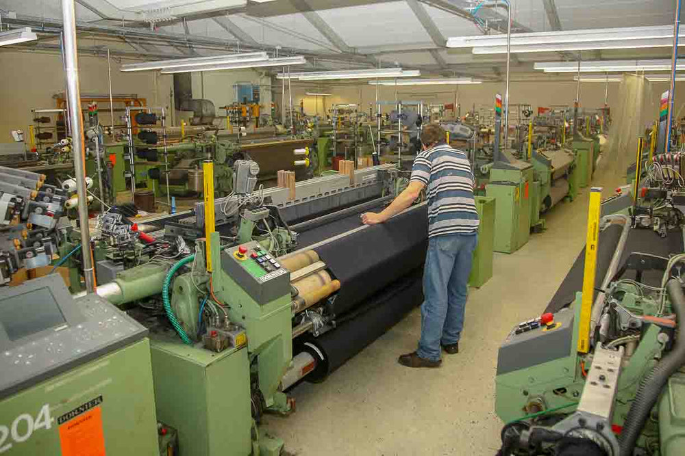 german man operating traditional loom for loden wool