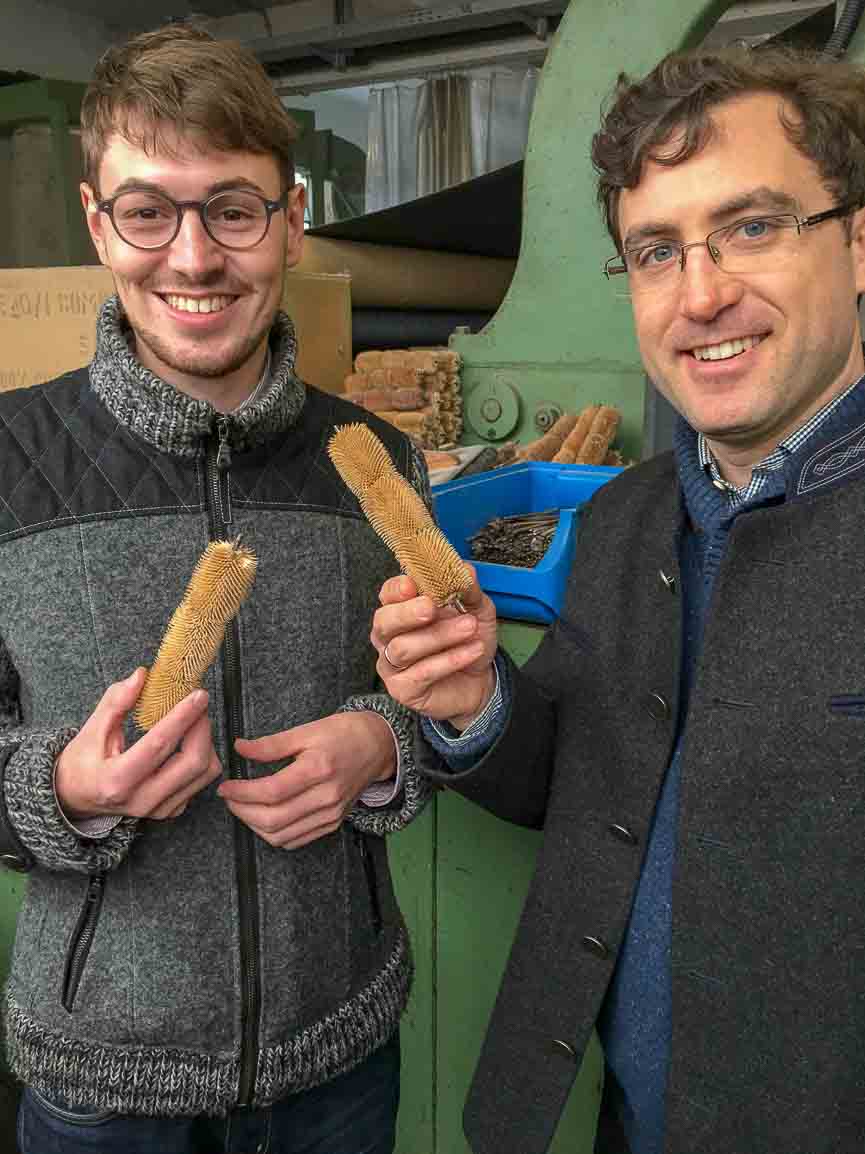Robert W. Stolz with Maximilian Mehler at Germany's oldest textile mill, Gebrüder Mehler, holding thistle heads used in traditional Loden manufacturing