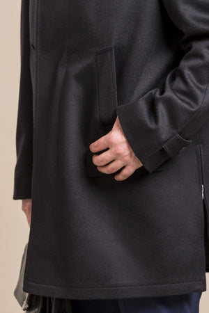 a close up view of the hand in a pocket of a 30 year old man wearing an austrian himalaya loden wool overcoat