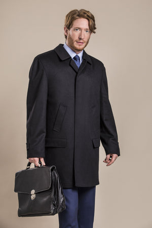 a side view of a 30 year old man wearing an austrian himalaya loden wool overcoat