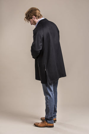 a backside view of a 30 year old man wearing an austrian himalaya loden wool overcoat