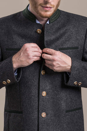 a front view of a 30 year old man buttoning an austrian loden wool jacket