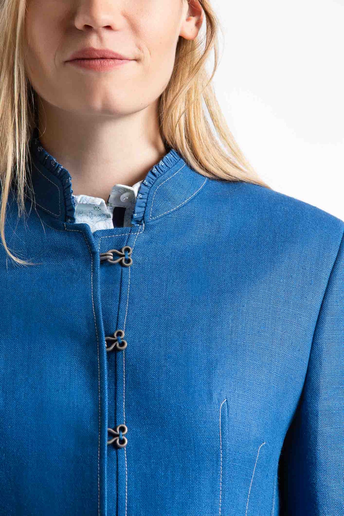 portrait of a young blonde women wearing a blue Austrian linen riding jacket