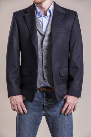 a frontal chest view of a 30 year old man wearing a wool blazer made from austrian himalya loden wool