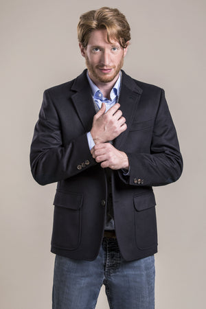 a frontal close view of a 30 year old man wearing a wool blazer made from austrian himalya loden wool