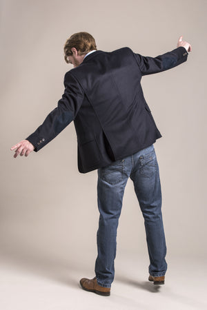 a backside view of a 30 year old man wearing a wool blazer made from austrian himalya loden wool